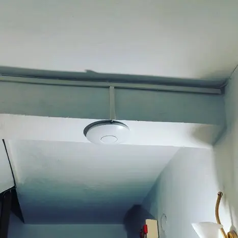 Οικιακό router Wi‑Fi πάνω σε γραφείο με φόντο σπίτι
