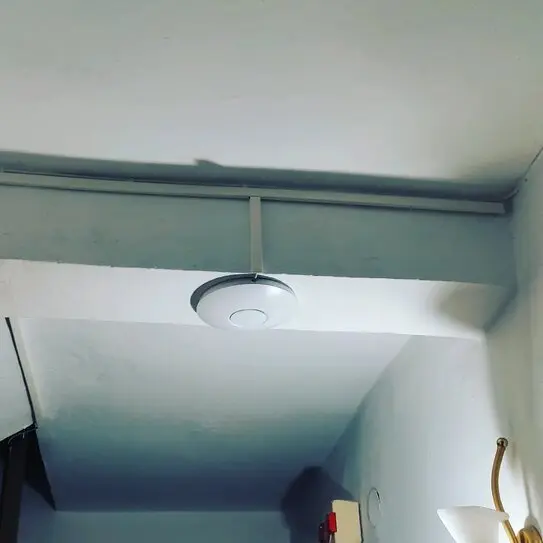 Οικιακό router Wi‑Fi πάνω σε γραφείο με φόντο σπίτι